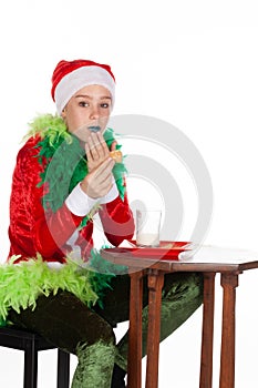 Closeup portrait of young girl wearing red santa clause hat mouthful with hand to mouth