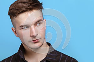 Closeup portrait of young handsome man with sidelong glance at right side.