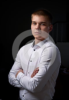 Closeup portrait of a young man, happy, cheerful, handsome businessman is standing in modern office in white shirt