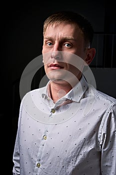 Closeup portrait of a young man, happy, cheerful, handsome businessman is standing in modern office in white shirt