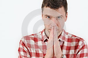Closeup portrait young man praying hands clasped hoping for best asking for forgiveness or miracle on white background