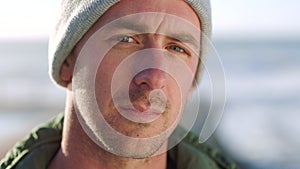 Closeup portrait of a young man staring and gazing seriously while standing outdoors. One unsmiling and unhappy man