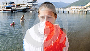 Closeup portrait of young mother inflating beach ball for her child on the beach
