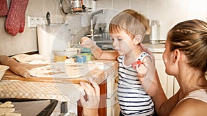 Detallado retrato joven madre un nino chico posesión horneando sartén a creación galletas sobre el La cocina 