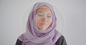 Closeup portrait of young pretty arabian woman in hijab looking at camera with background isolated in white