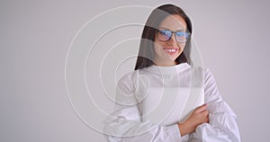 Closeup portrait of young pretty caucasian businesswoman in glasses holding a laptop looking at camera smiling happily