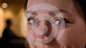 Closeup portrait of young pretty caucasian female face with eyes looking straight at camera with cheerful facial