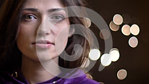 Closeup portrait of young pretty caucasian female model smiling and posing in front of the camera with her hair being