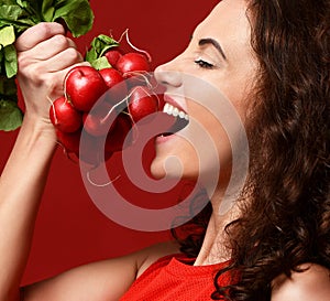 Closeup portrait of young sport woman eating fresh radish green