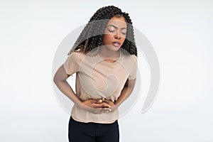 Closeup portrait of young, stressed woman, placing hands on stomach having bad aches and pains, isolated on white background. Food