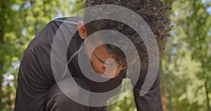 Closeup portrait of young strong African American male jogger preparing to run in the park outdoors