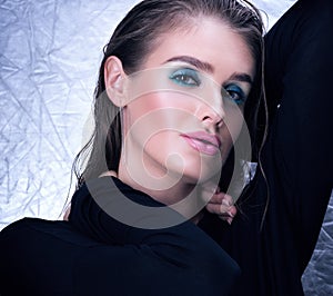 Closeup portrait of young woman in black. Professional makeup and wet hair