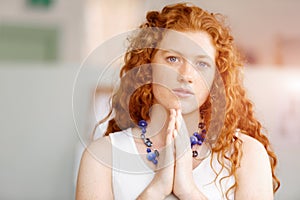 Closeup portrait of a young woman praying