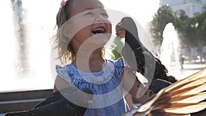 Closeup portreit of little cute girl feeding street pigeons in the park