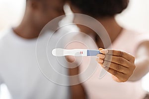 Closeup of positive pregnancy test in black woman hands