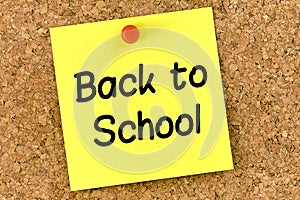 Closeup post it note on corkboard with back to school  message on it