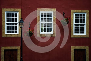 Closeup of potted flowers on a wall of a red residential building in Teror, Gran Canaria, Spain