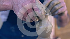 Closeup of potter making clay vase on mechanical pottery wheel