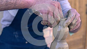 Closeup of potter making clay vase on mechanical pottery wheel
