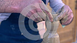 Closeup of potter making clay vase on mechanical pottery wheel