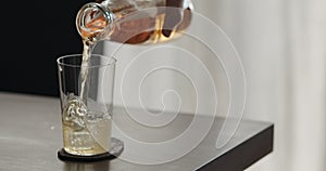 closeup pour mate drink in a tumbler glass on walnut table with copy space