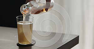 closeup pour mate drink in a tumbler glass on walnut table with copy space