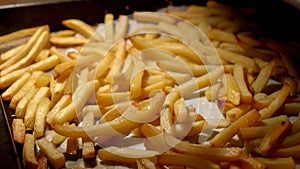 Closeup of pouring oil on frying french fries in oven. Fast food, healthy nutrition, cooking in oven