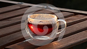 Closeup pouring stream fresh aroma hot black tea into transparent glass double bottom cup from teapot serving breakfast