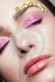 Closeup pov shot of human female face with pink eyes shadows. Eyes closed