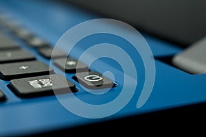 Closeup of a power button on a blue laptop