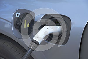 Closeup of a power cable supple plugged in an electric car at a charging station