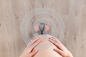 Pregnant woman standing on scales