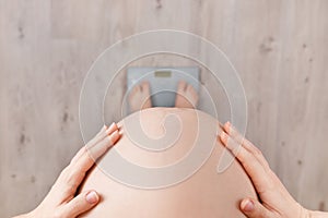 Pregnant woman standing on scales