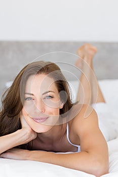 Closeup of a pretty smiling woman lying in bed