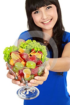 Closeup of a pretty young girl with fruit salad