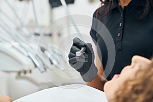 Closeup of probe in hands of dentist while brushing teeth