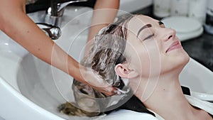 Closeup of process of washing client's hair in beauty salon