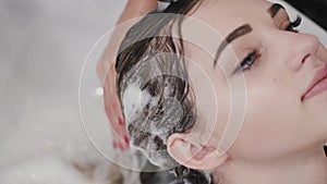 Closeup of process of washing client's hair in beauty salon