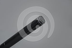 Closeup of a professional black metal microphone for recording on gray background