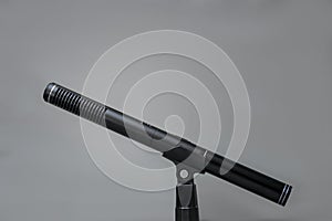 Closeup of a professional black metal microphone for recording on gray background