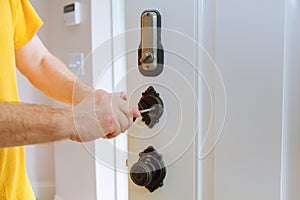 Closeup of a professional locksmith installing or repairing a new deadbolt lock photo