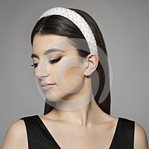 Closeup profile of confident young woman with hairband looking forward isolated on gray background photo