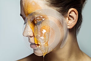 Closeup profile side view portrait of beautiful young brunette woman with freckles and honey on face with closed eyes and serious