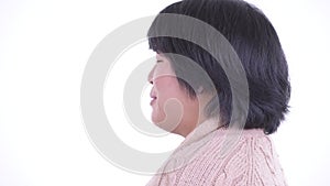 Closeup profile view of happy overweight Asian woman talking and ready for winter