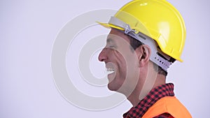 Closeup profile view of young happy Hispanic man construction worker smiling