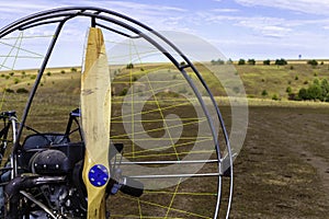 Closeup of a propeller with a motor-paraglider motor against the background of a field.