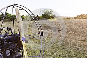 Closeup of a propeller with a motor-paraglider motor against the background of a field.