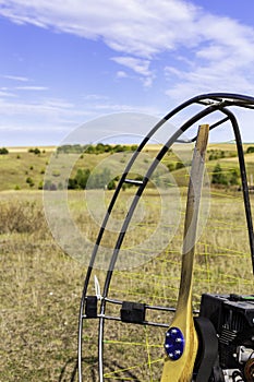 Closeup of a propeller with a motor-paraglider motor against the background of a field