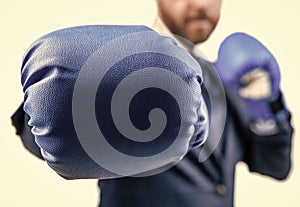 closeup punch of cropped businessman in boxing gloves ready for corporate business battle, knockout.