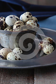 Closeup of quail eggs with plates on wood table